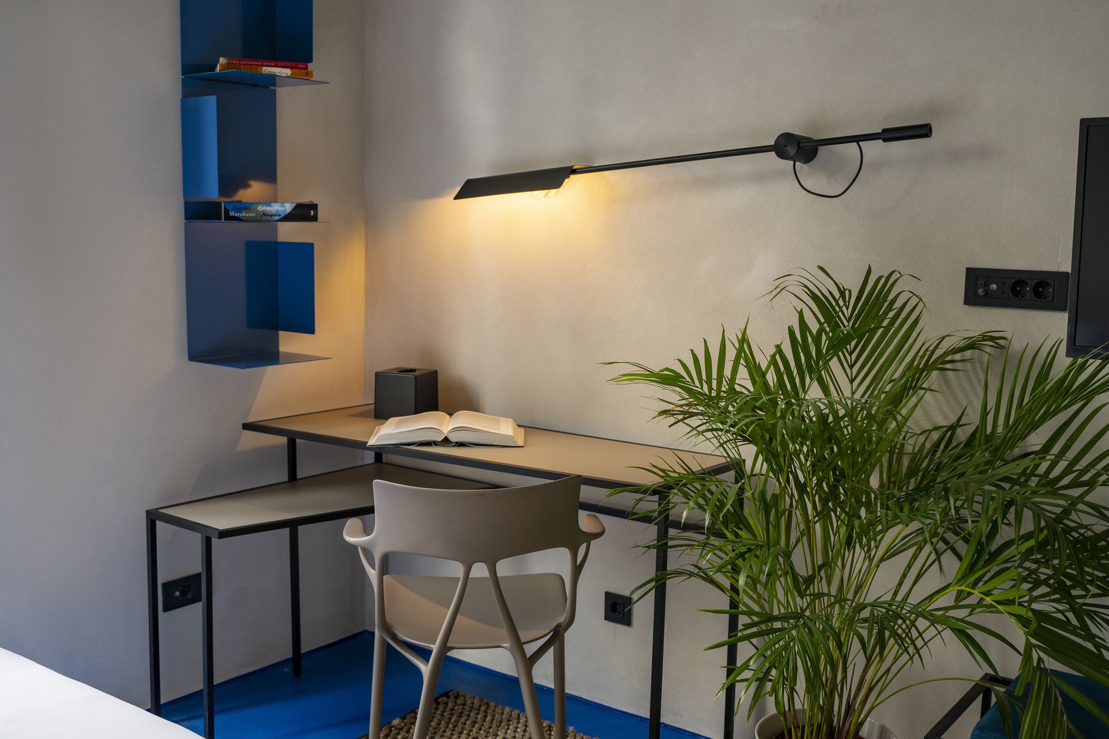 Un espacio de trabajo moderno con un escritorio, una silla y una planta en maceta.