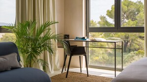 A room with a large window, a desk with a chair, a plant, and a bed. - Moro Inn  (Korcula)