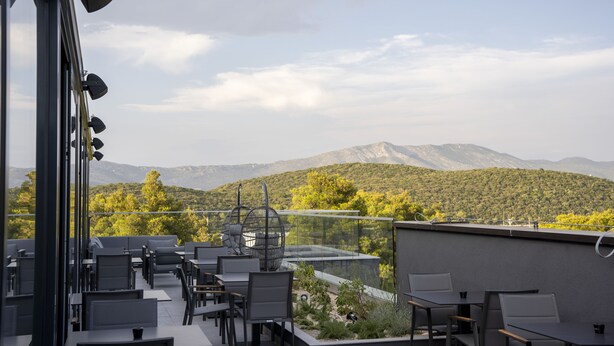 An outdoor terrace with seating and a view of a mountainous landscape. - Moro Inn  (Korcula)