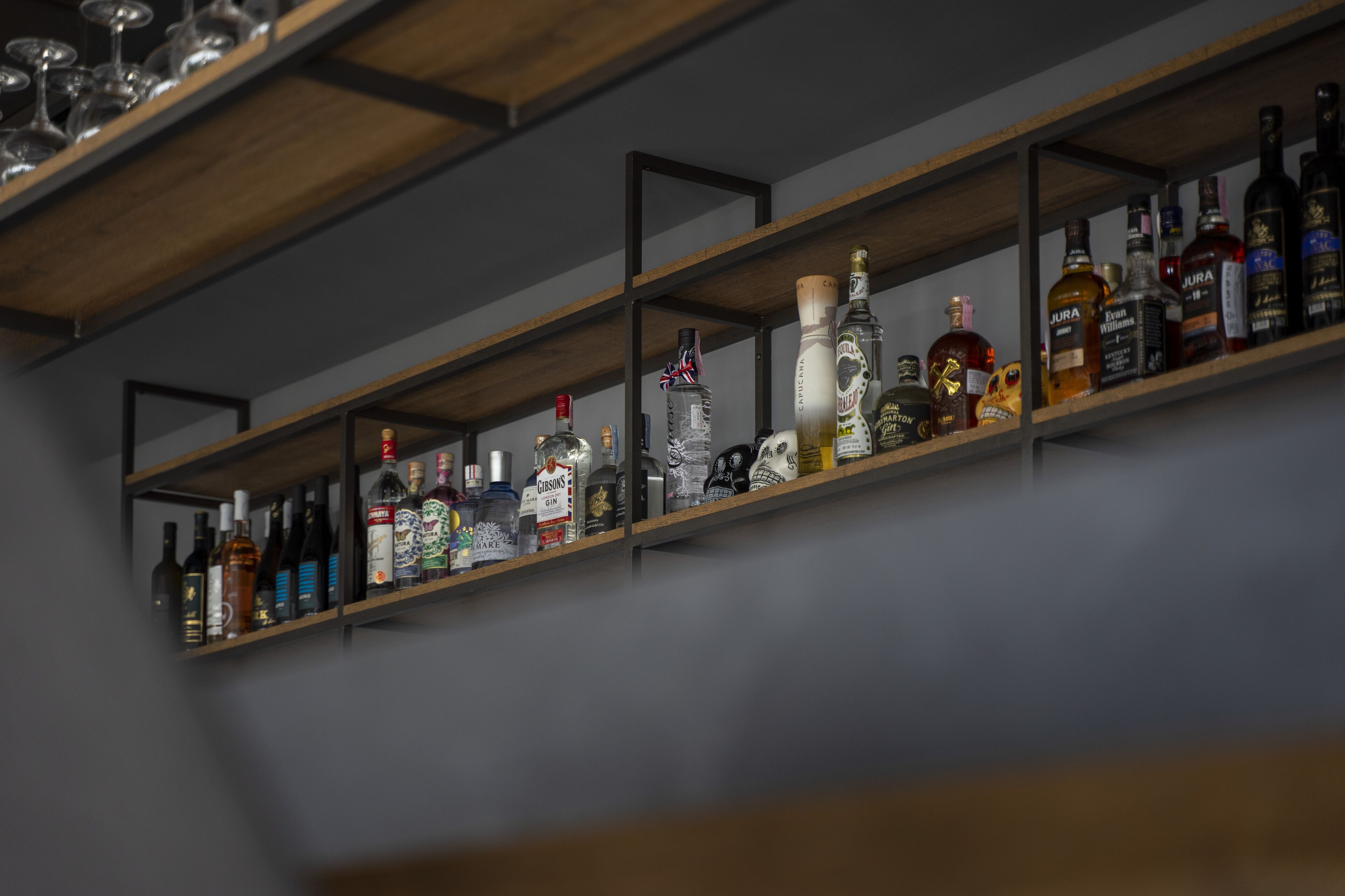 A bar area with shelves stocked with various liquor bottles.