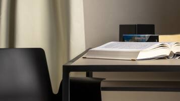 Um espaço de estudo com escrivaninha, cadeira e livros.