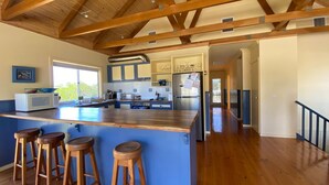 A kitchen with a wooden island, bar stools, a microwave, and a refrigerator. - After Dune Delight, Indulge in your Ocean views. (Inverloch)