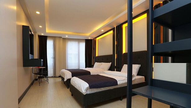 A hotel room with two beds, a desk, and a chair. - Galata King Suites (Istanbul)