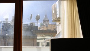 A view through a window with a building featuring a prominent tower and multiple satellite dishes. - Galata King Suites (Istanbul)
