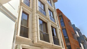 A multi-story building with a classical architectural style, featuring a symmetrical facade with evenly spaced windows and a central entrance. - Galata King Suites (Istanbul)