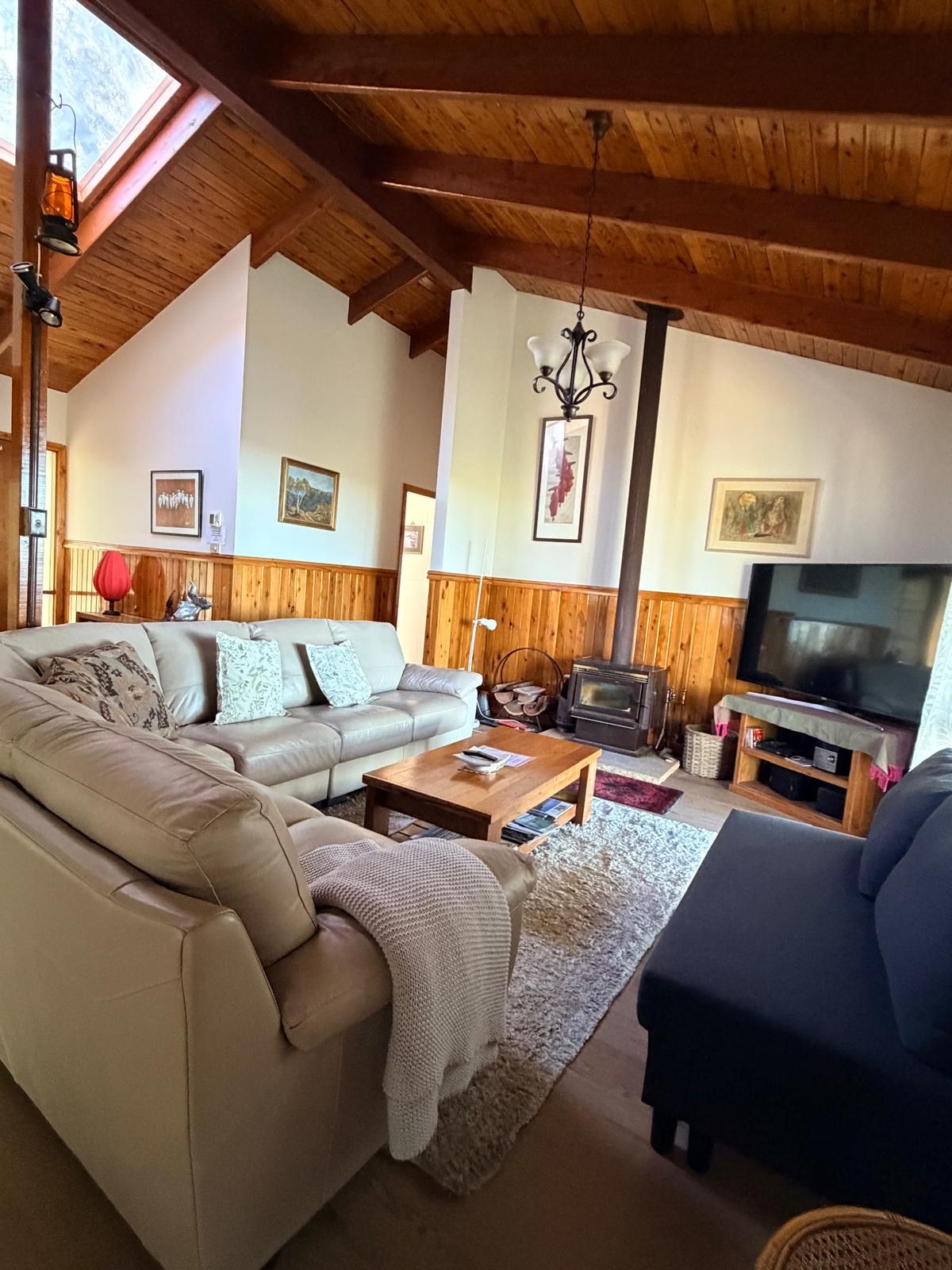 A cozy living room with a sofa, coffee table, and a television.