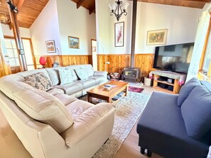 A cozy living room with a sofa, a coffee table, a fireplace, and a television. - Canyon Cottage ~ Majestic view (Blackheath)