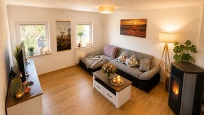 A living room with a sofa, a coffee table with candles, a fireplace, and artwork on the walls.
