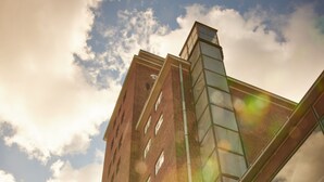 A tall brick building with large windows and a glass facade. - Pierspeicher Boardinghouse (Kappeln)