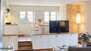 A modern living room with a flat-screen TV, a sofa, and a coffee table. - Pierspeicher Boardinghouse (Kappeln)