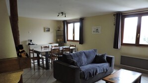 Ein Wohnzimmer mit einer Couch, einem Couchtisch und einem Essbereich mit Tisch und Stühlen.
