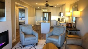 A modern living room with two grey armchairs, a wooden coffee table, and a fireplace. - Winter Paradise! NEW 2B/2B Walk to slopes Hot tubs (Snowshoe)