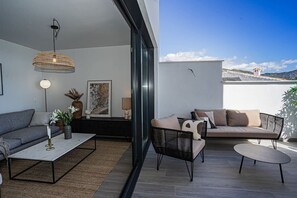 A modern living room with a sofa, coffee table, and a wicker pendant light.