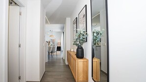 Ein Flur mit einem Holztischchen, einem großen Spiegel und gerahmten Bildern.