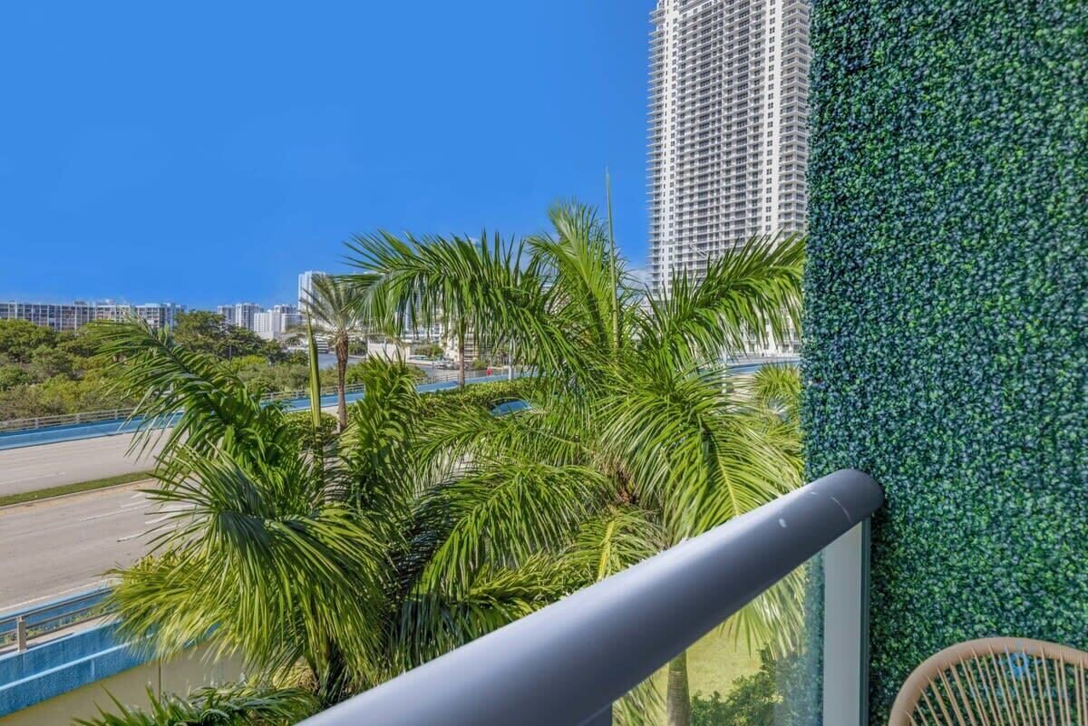 Um edifício alto com vista para uma estrada e palmeiras.