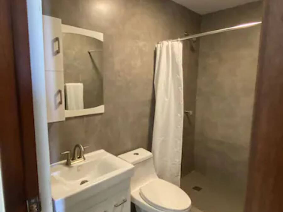 A modern bathroom with a sink, toilet, and shower.