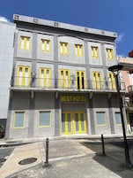 Un edificio con varias ventanas y balcones, con la leyenda "NEST HOTEL".