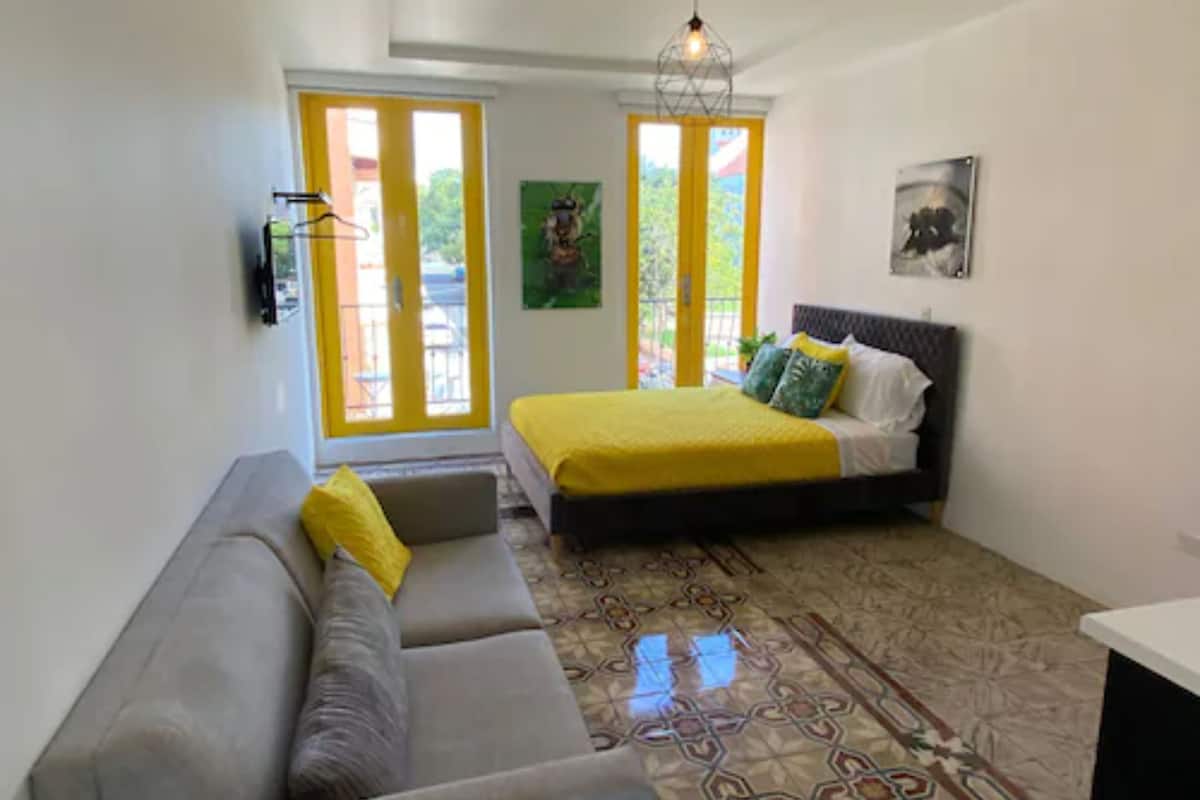 Une chambre à coucher avec un lit, un canapé et un sol à motifs.