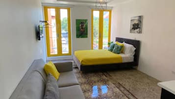 Un dormitorio con una cama, un sofá y un suelo estampado.