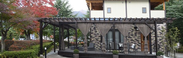 Ein überdachter Außenbereich mit Steinmauern und einer Holz-Pergola.