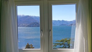 Ein Fenster mit Blick auf einen See und Berge.