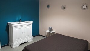 A bedroom with a bed, a white dresser, a bedside table, and a wall with three decorative items. - 43 m² apartment with balcony, 80 m from Demoiselles beach, (Saint-Hilaire-de-Riez)