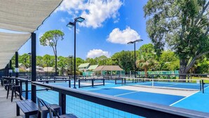 A pool area with blue tiles, benches, and a covered seating area.