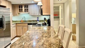 A modern kitchen with granite countertops, stainless steel appliances, and wooden cabinets.