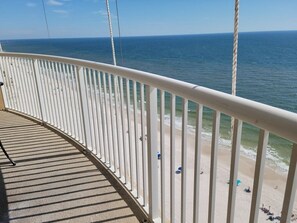 Ein Balkon mit Blick auf Strand und Meer.
