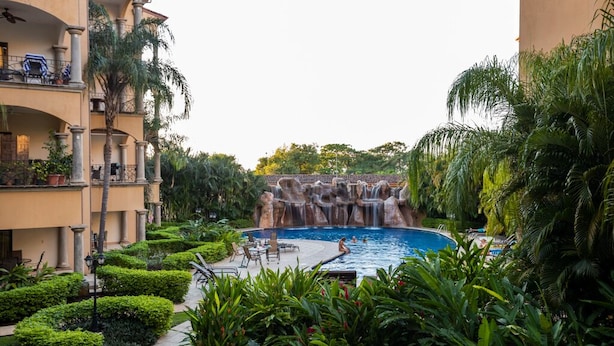 Un hôtel doté d’une piscine, d’une végétation luxuriante et d’une cascade.