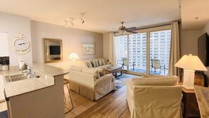 Un apartamento moderno con cocina, sala de estar y amplios ventanales que ofrecen vistas a la ciudad.
