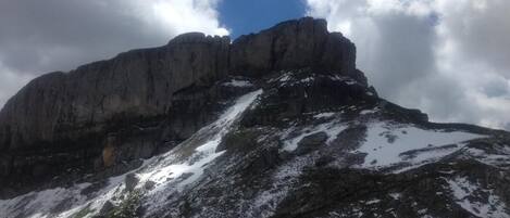 A mountain with a rocky peak and snow patches.