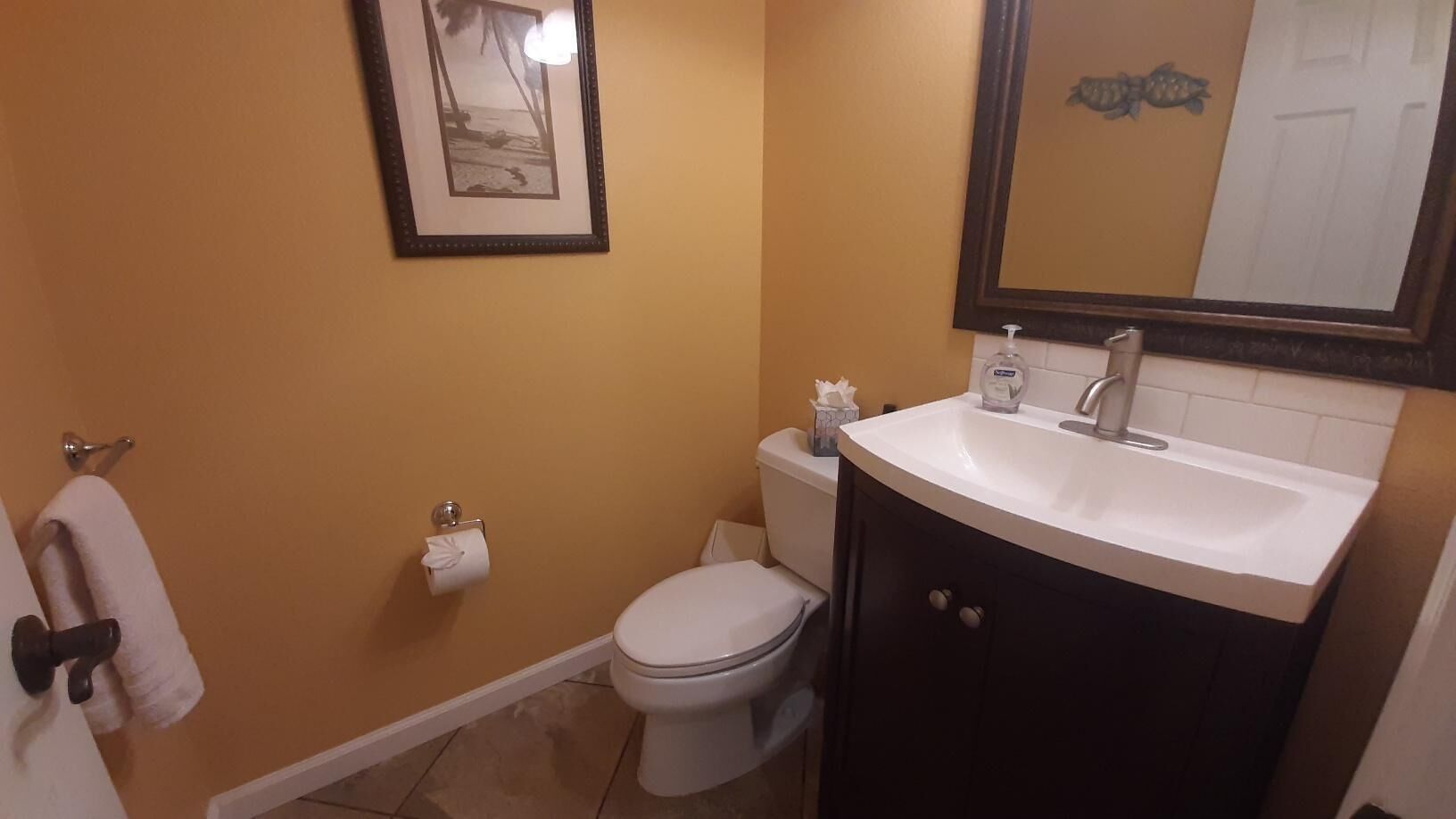 A bathroom with a toilet, sink, and towel rack.