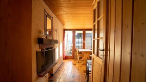 A wooden interior with a fireplace, a dining area, and large windows. - Small apartment on the ski slopes (Gryon)