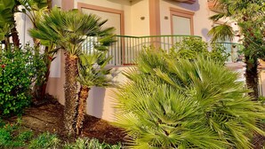 A multi-story building with balconies, surrounded by tropical plants. - Casa Da luz 5, ocean view, pool & beach 200 meters away  (Praia da Luz)