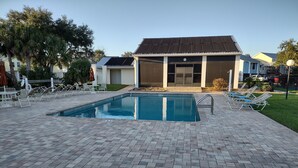 A swimming pool with lounge chairs and a building in the background.