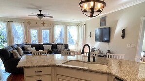 A modern kitchen with a granite countertop, white cabinetry, and a built-in dishwasher. - Modern farm Home Close to Jordan lake and Downtown apex (Apex)