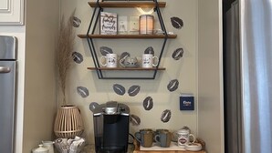 A kitchen with a coffee-themed decor, including a coffee machine, mugs, and a shelf with coffee-related items. - Modern farm Home Close to Jordan lake and Downtown apex (Apex)