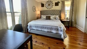 A bedroom with a large bed, a ceiling fan, a round wall clock, and a dining table. - Modern farm Home Close to Jordan lake and Downtown apex (Apex)