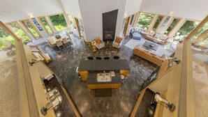 Una cocina moderna con una isla central, ventanas amplias y una chimenea.
