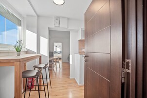 Una cocina moderna con armarios de madera, horno empotrado y una ventana sobre la encimera.