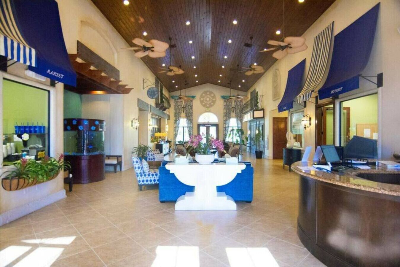 Un hall d’entrée spacieux comprenant un comptoir de réception, un espace salon et une grande fontaine décorative.