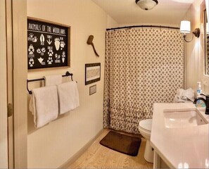 Une salle de bain équipée d’une douche avec rideau, d’un lavabo, de toilettes et d’un porte-serviettes avec deux serviettes.