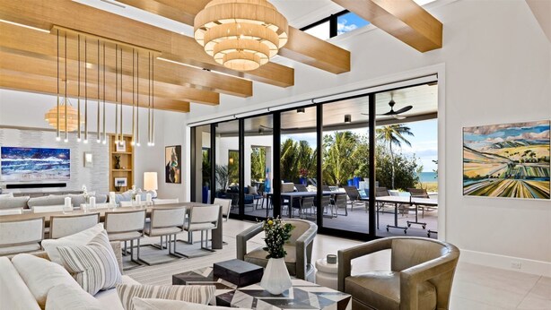 Amplia sala de estar con un ventanal grande, zona de comedor y vistas al exterior.