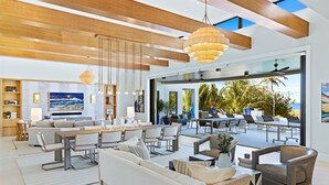 Amplia sala de estar con una gran mesa de comedor, asientos cómodos y vistas al exterior.