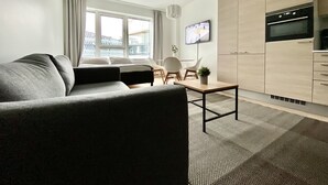 Ett modernt vardagsrum med en soffa, ett soffbord och en tv som är monterad på väggen.