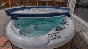 A hot tub with a control panel, surrounded by a wooden deck and a wooden fence. - Spacious 6BR Home with Hot Tub, Hammocks and Firepit (Denver)