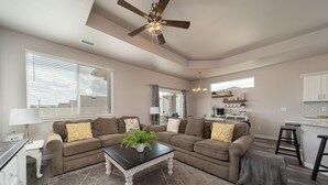 A spacious living room with a large sectional sofa, a coffee table, and a ceiling fan. - Brand new, 3 bedroom piece of  paradise! (Grand Junction)