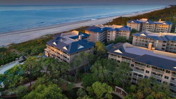 Ein Resort mit mehreren Gebäuden, einem Pool und Blick auf den Strand.