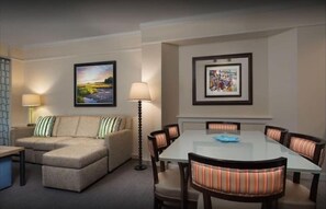 Relax in a spacious seating area with a sofa and dining table for six, perfect for unwinding and enjoying meals.